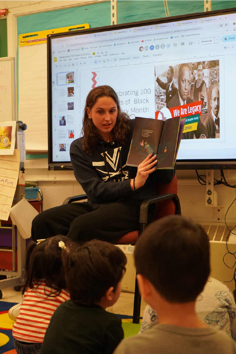 Aimee Canny and Anna Moesh (UVA Swim and Dive) read to kids at Greenbriar Elementary for Black History Month with the 100 Black Men of Charlottesville.